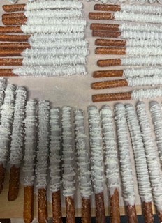 White chocolate-covered pretzel rods arranged in rows