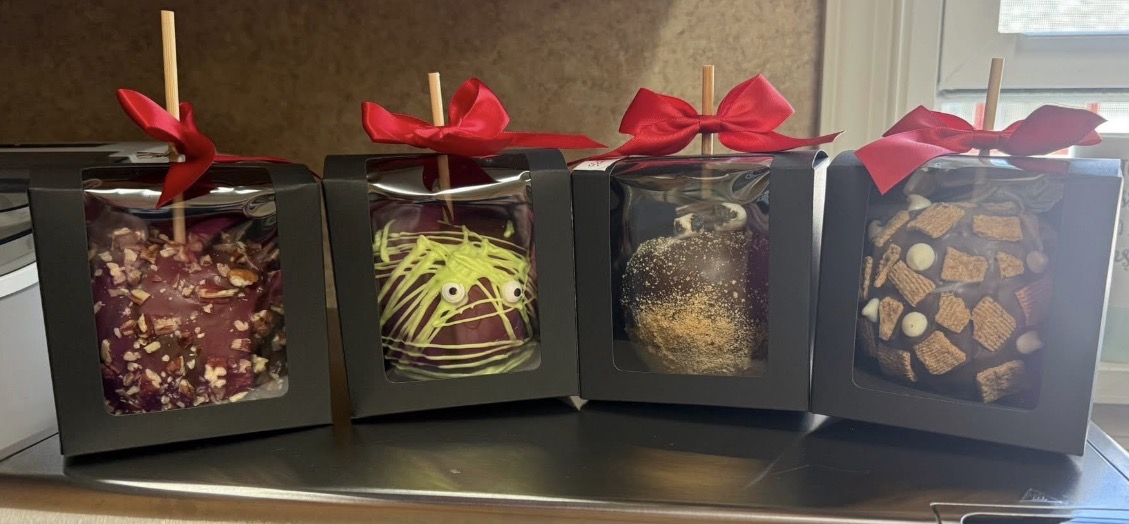 Decorated chocolate-covered treats in gift boxes with red bows
