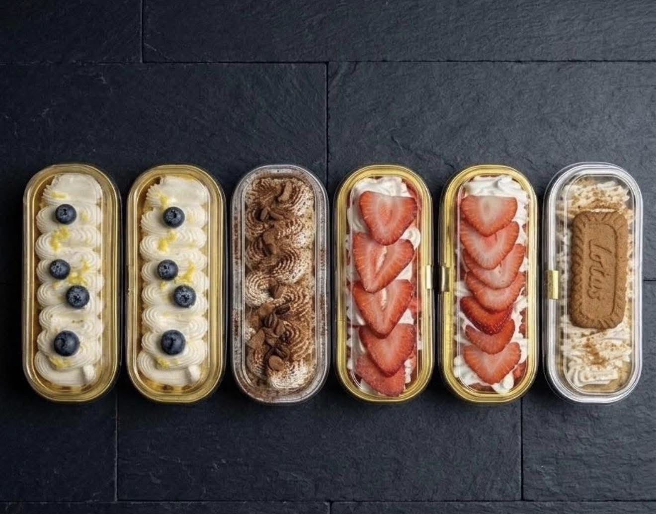 Assorted mini cakes with fruit, chocolate, and cookie toppings