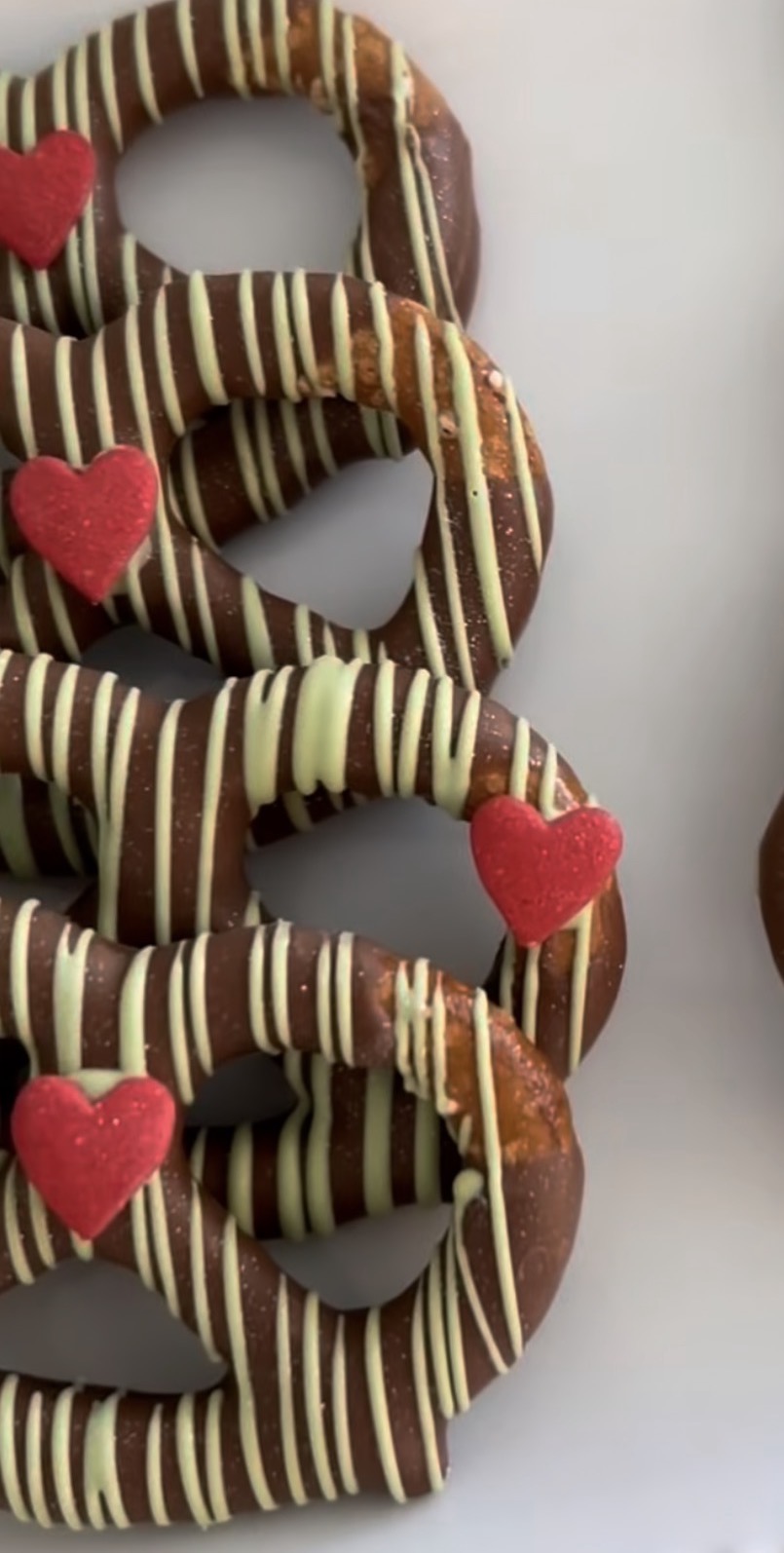 Chocolate-covered pretzels with drizzle and heart decorations
